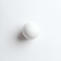A single, pristine white sphere rests on a stark white background.  Its smooth surface and subtle shadow create a minimalist image