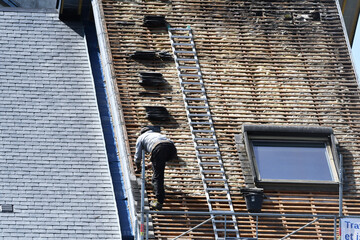 ouvrier couvreur sur un toit d'habitation en rénovation