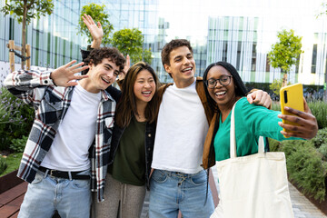 Group of happy multiracial students taking a selfie and waving to the camera