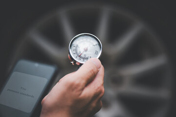 Mechanic holding pressure gauge for car tyre pressure measurement