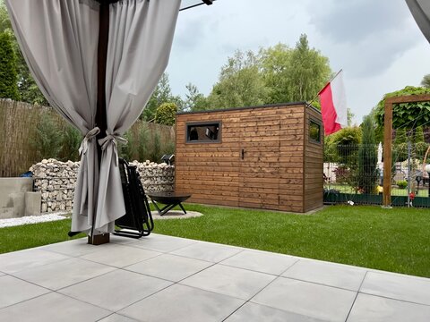 Stylowy, nowoczesny taras z widokiem na zadbany ogr&oacute;d. Połączenie eleganckiej architektury z naturą &ndash; idealna przestrzeń do relaksu i spędzania czasu na świeżym powietrzu.