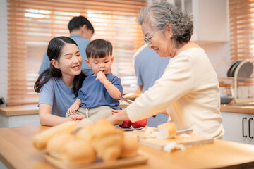 Fototapeta premium Family enjoying cooking together in a bright kitchen with smiles and engagement during a weekend activity