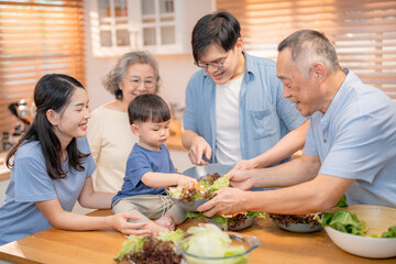Family members enjoying a lively cooking session together in a bright kitchen while preparing a fresh salad with laughter and joy