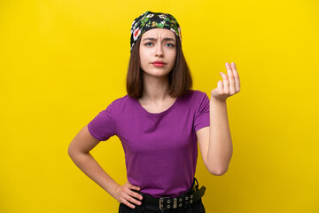 Young Ukrainian woman isolated on yellow background making Italian gesture