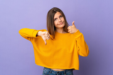 Young Slovak woman isolated on purple background making good-bad sign. Undecided between yes or not
