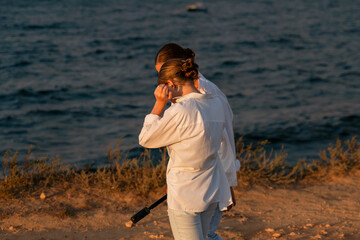 Man, Beach, Sunset - Person holding wooden stick looking out at ocean sunset.