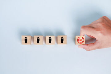 Hand selecting wooden cube with target customer icon. Marketing segmentation, recruitment concept,...
