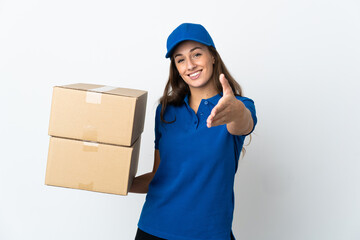 Young delivery woman over isolated white background shaking hands for closing a good deal