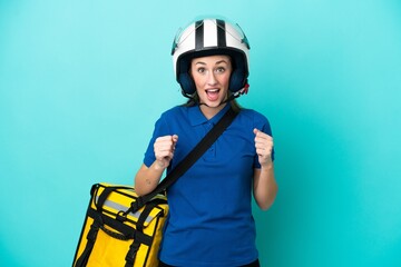 Young caucasian woman with thermal backpack isolated on white background celebrating a victory in winner position