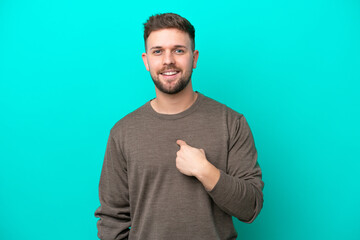 Young caucasian man isolated on blue background with surprise facial expression