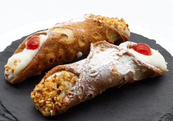 Two Delicious Italian Cannoli Siciliani on a Dark Slate Plate
