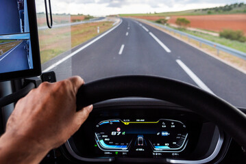 Truck dashboard screen while driving on a highway, showing speed and engine RPM data focused on fuel efficient driving.