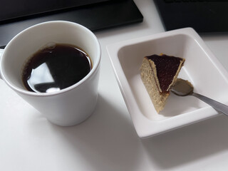  テーブルの上のコーヒーカップとケーキの一切れ