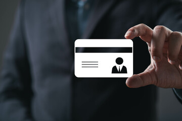 A person holds a blank identification card, emphasizing professionalism and identity in a dark, subdued environment.