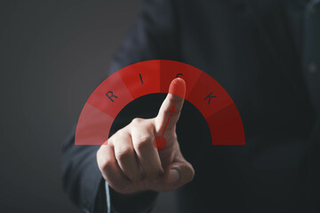 A businessman interacts with a risk gauge, indicating attention to risk management and decision-making in a professional context.