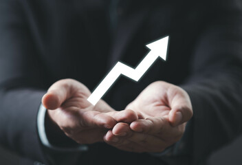 A pair of hands holds an upward arrow, symbolizing growth, success, or progress in a professional context.