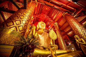 Background of religious tourist attractions in Ayutthaya, Thailand. Wat Phanan Choeng, Wat Luang Pho To, has an ancient golden-yellow Buddha statue. Tourists always come to make merit.