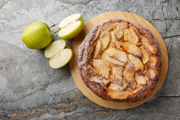 Freshly baked clafoutis pie with apples with vanilla and cinnamon close-up on a wooden board on the table. Horizontal top view from above