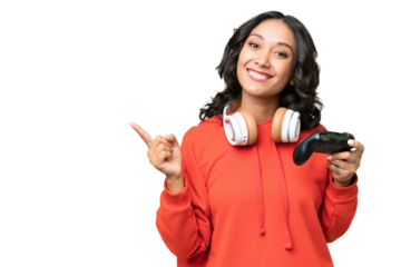 Young Argentinian woman playing with a video game controller over isolated background pointing finger to the side