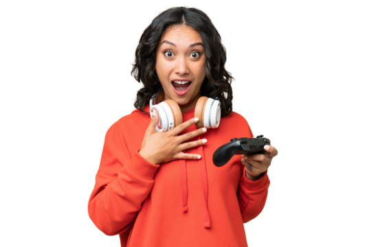 Young Argentinian woman playing with a video game controller over isolated background surprised and shocked while looking right