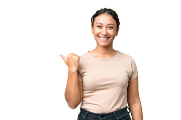 Young Uruguayan woman over isolated chroma key background pointing to the side to present a product