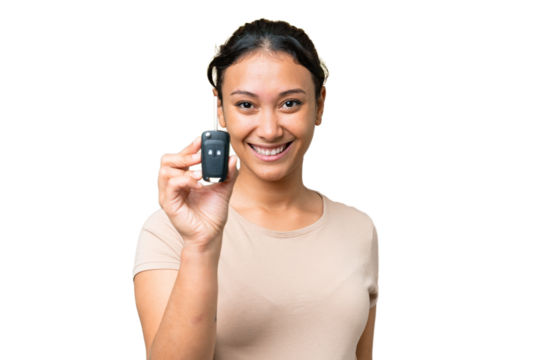 Young Uruguayan woman holding car keys over isolated chroma key background with happy expression - Powered by Adobe