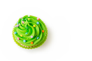 Delicious cupcake with bright green frosting and decorative sprinkles on white background, top view