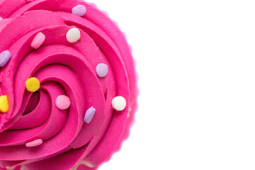 Close-up of pink cupcake frosting and sprinkles on white background, top view