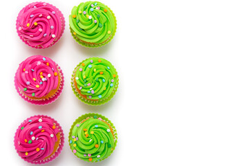 Colorful cupcakes with pink and green frosting arranged on white background