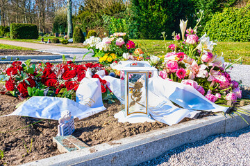 Kränze und Schleifen auf einem frischen Grab