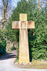 Großes Steinkreuz als Mittelpunkt auf einem Friedhof