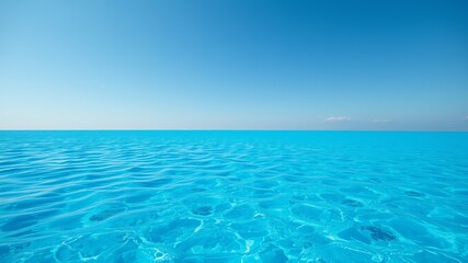 Obraz premium A stunning panoramic view of a calm turquoise ocean under a vibrant blue sky on a sunny day.