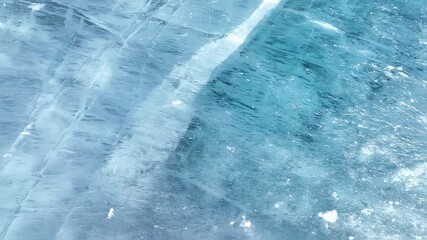 Close up view of cracked crystal blue ice surface. Frozen water texture and pattern of natural ice. Winter nature background footage. - Powered by Adobe