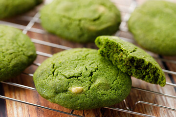 Chewy matcha chocolate chip cookies on cooling rack.