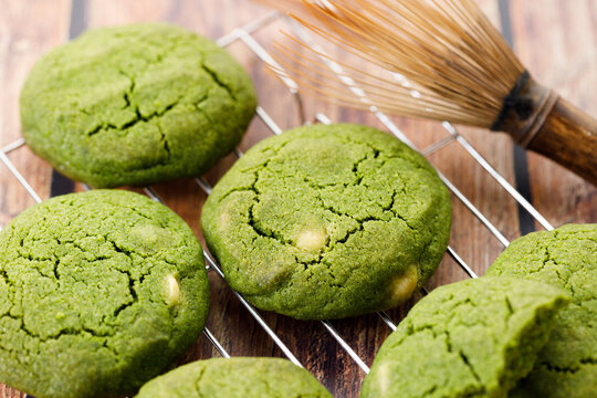 Chewy matcha chocolate chip cookies on cooling rack.