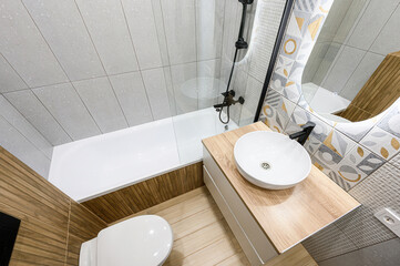 Modern bathroom featuring a tub, sink, toilet, and stylish tile work. Clean design with neutral...