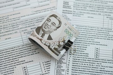 North Korean won money bills in big amount lies on table with tax forms close up