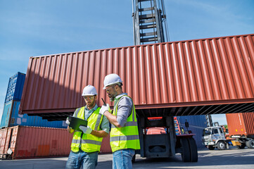 Logistics engineer and inspector working and discuss in shipping container in commercial transport port
