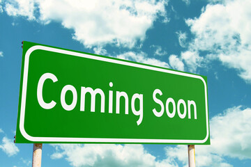 Coming Soon Green Road Sign with clouds sky background