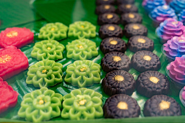 Display of intricately crafted Thai desserts called Khanom Chor Muang. These are traditional Thai desserts made to resemble flowers, using natural food coloring and shaped to look like rose flower.