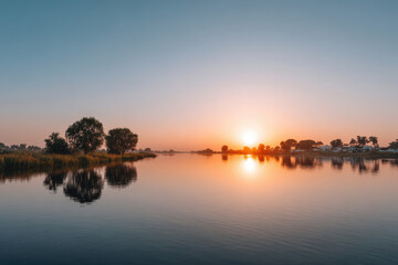 Fototapeta premium serene sunset reflecting on calm water surface showcasing minimalist beauty