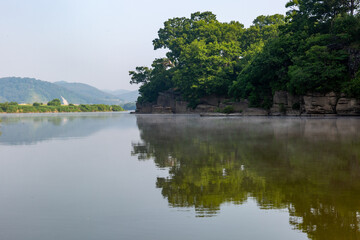 Obraz premium A riverfront view on a spring day full of red poppies, cornflower, babys breath and spring flowers. A view of the Akyang banks near the Namgang River in Haman-gun, Gyeongsangnam-do, Korea.