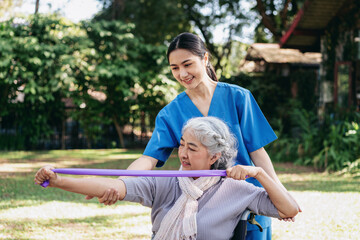 The woman in the wheelchair is holding a purple exercise band