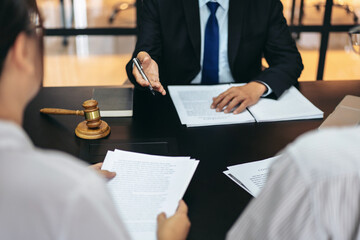 A man in a suit is sitting at a table with two other people