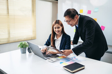 A man and a woman are working together on a laptop