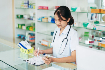 A nurse is writing on a clipboard in a pharmacy
