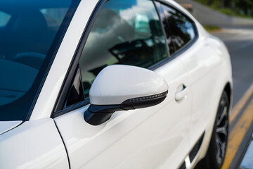 White luxury cars sleek side mirror with LED signal and tinted window