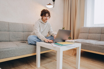Fototapeta premium Teen student girl studying at home using laptop and notebooks