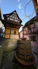 Typical houses in the French village of Eguisheim with a wine press on the street.