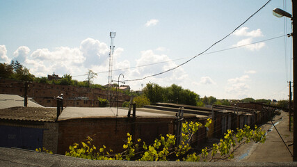 Cloudy skies over industrial buildings and utility poles